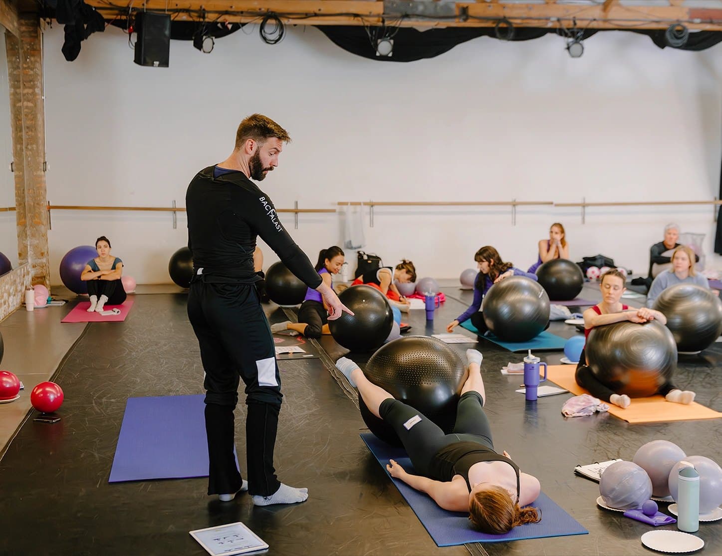 PBT tutor guiding a teacher through a conditioning exercise at a live workshop